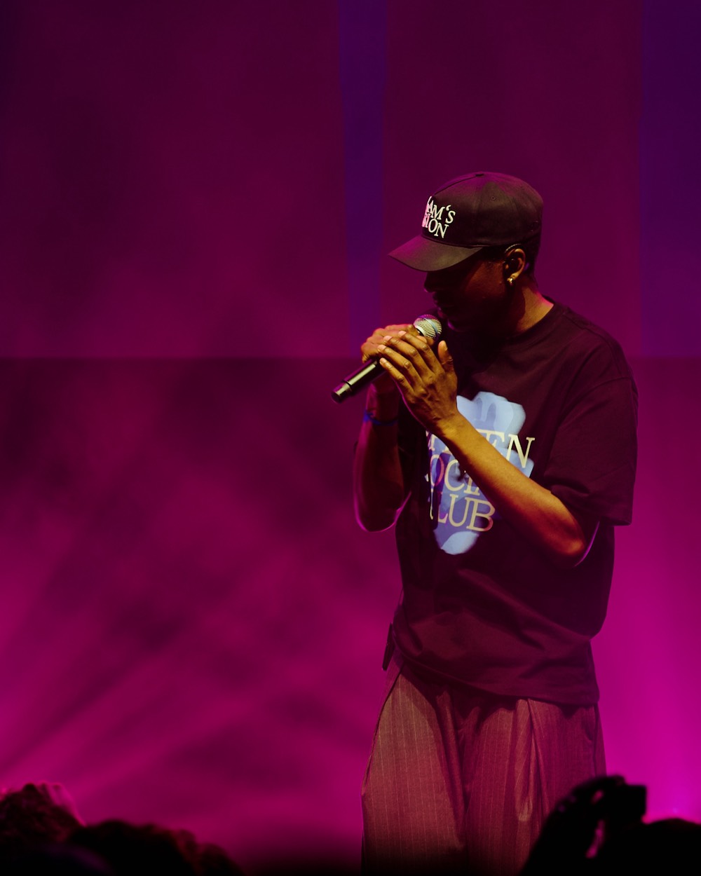 Rappeur au micro dans une lumière magenta