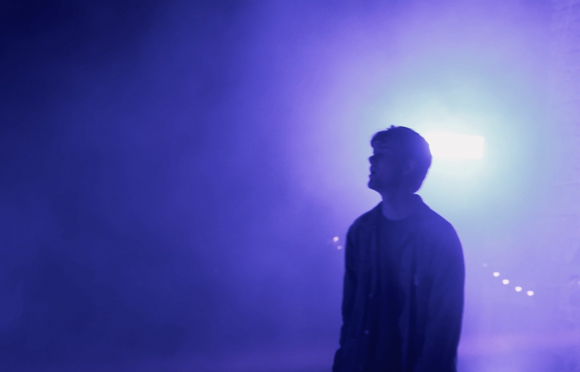 Silhouette d'un chanteur dans un brouillard violet, en concert